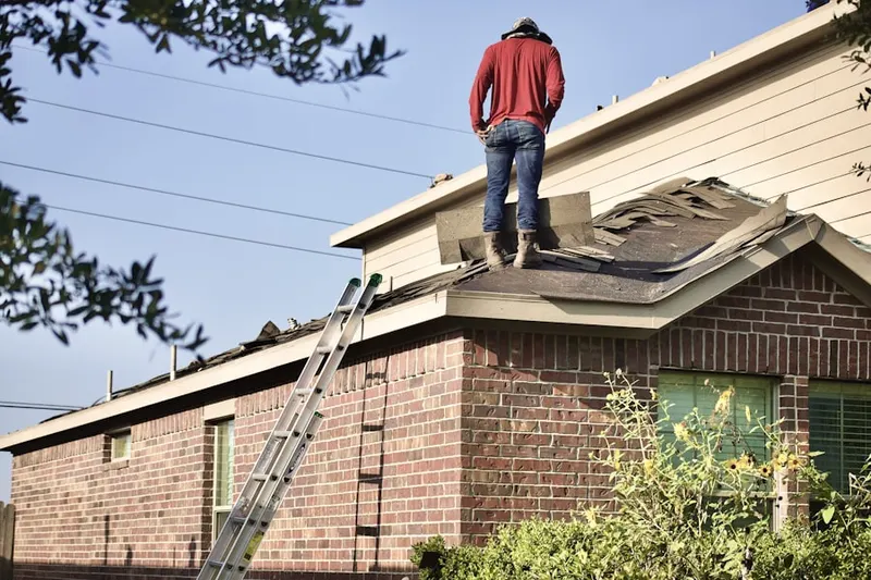 Professional roofer working on a residential roof in Hill Land